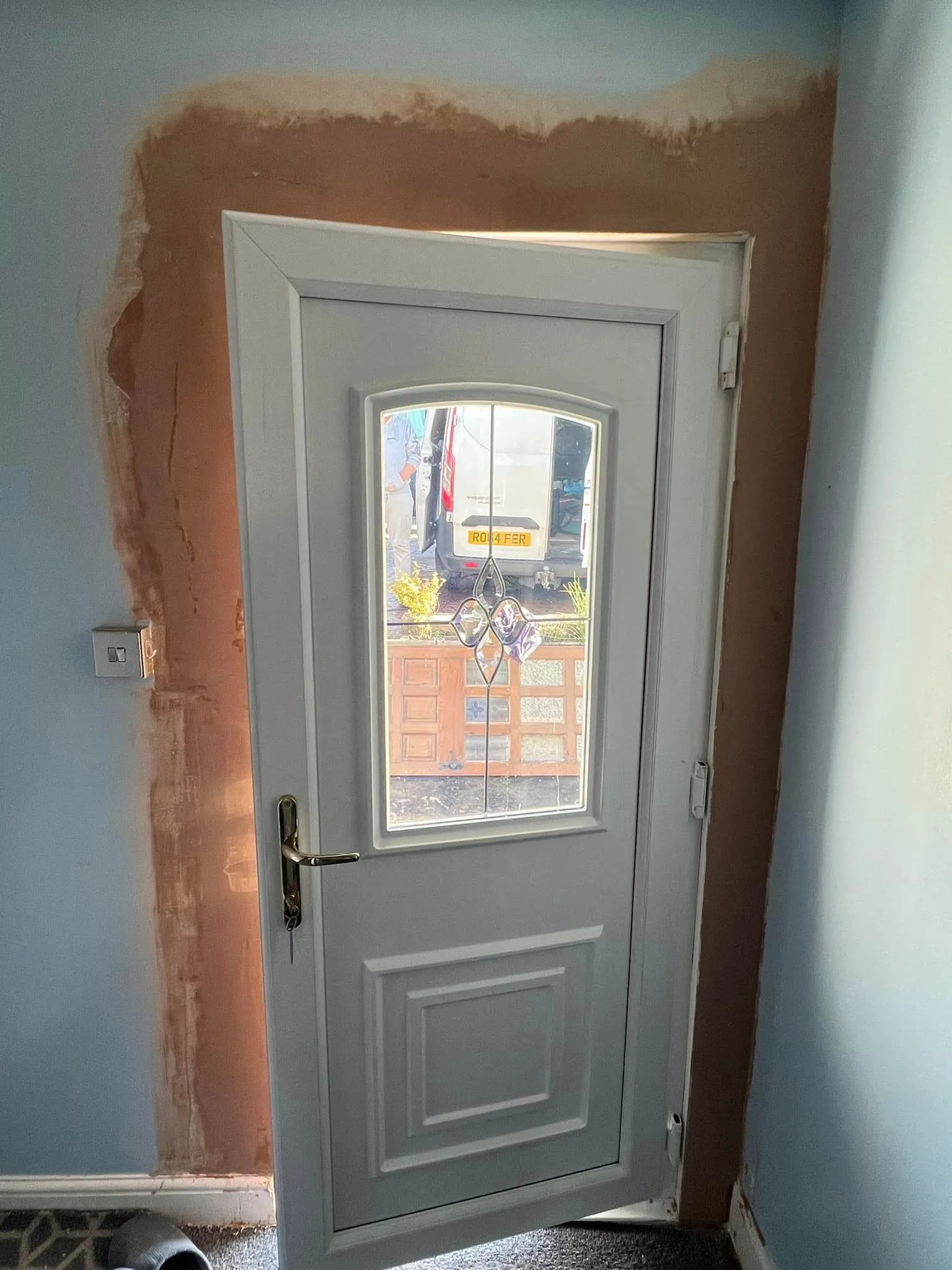A white door with a window in the middle of a room.